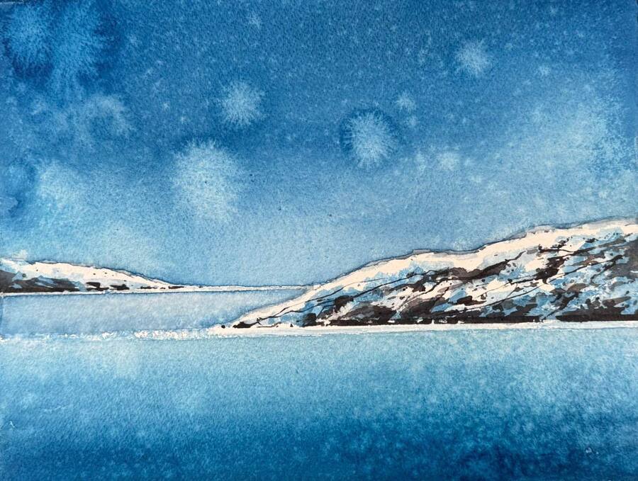 Snötäckt kust med öar och stilla blått vatten.