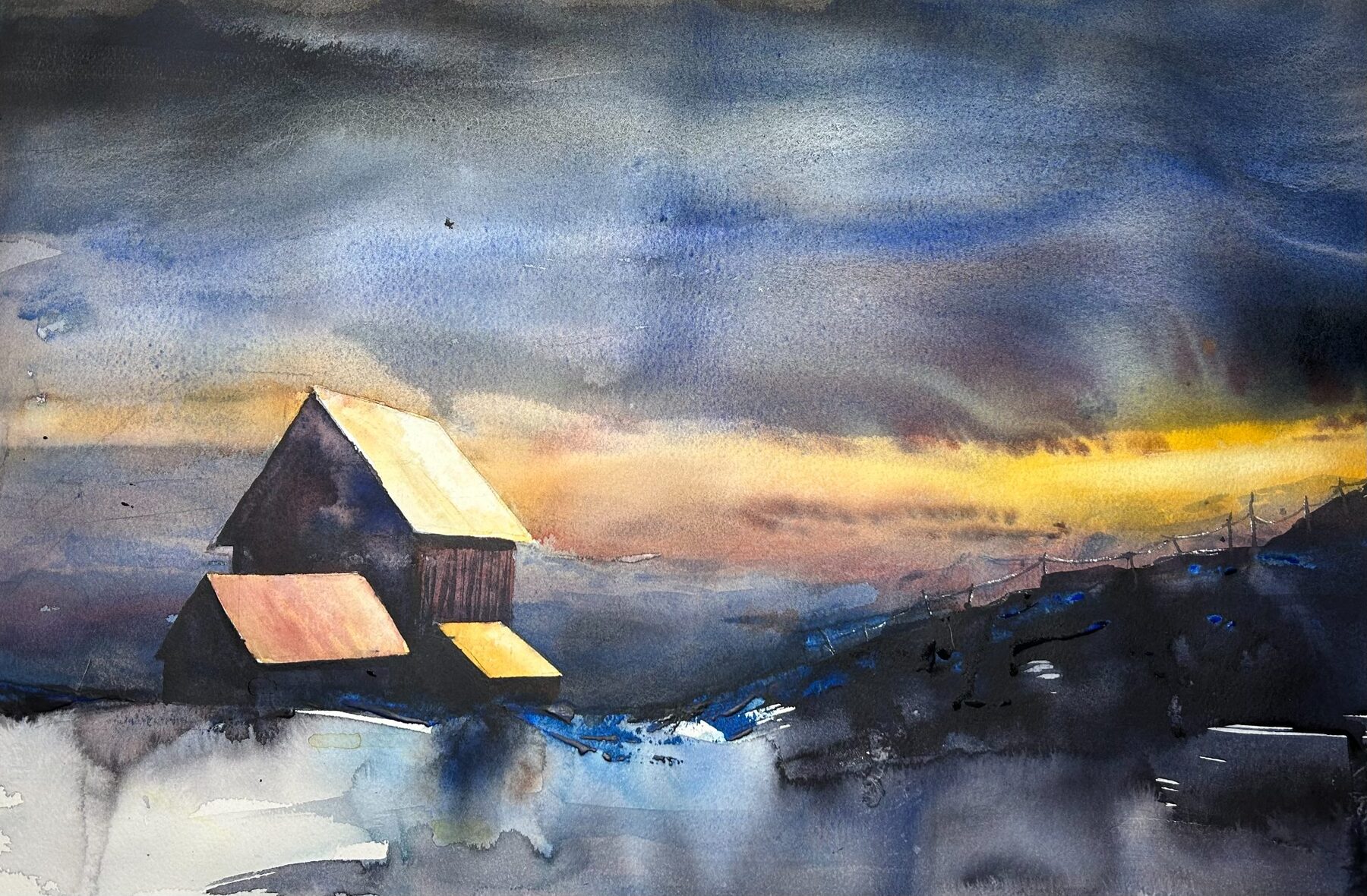 Barns at twilight under a dramatic blue and orange sky.